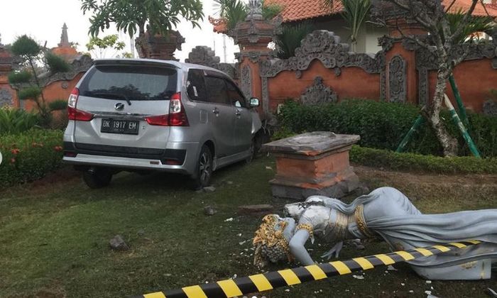 Toyota Avanza nyusruk ke taman di depan bandara Ngurah Rai, Bali