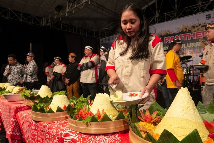 Anggota Ladies Panther Mania potong tumpeng dalam acara ulang tahun Panther Mania yang kesepuluh.