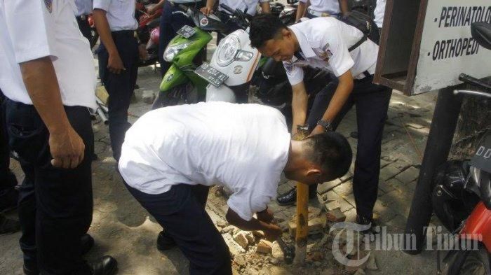 Petugas Dinas Perhubungan (Dishub) Kota Makassar mencabut tiang penyangga rantai yang digunakan sebagai pembatas lahan parkir.