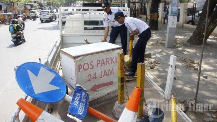Petugas Dinas Perhubungan (Dishub) Kota Makassar mengangkut barang-barang yang digunakan pos parkir yang menggunakan jalus pedestrian sebagai lahan.