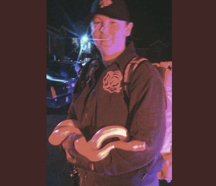 Petugas pemadam berfoto bersama ular yang mereka tangkap.