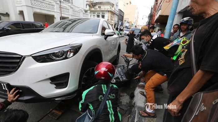 Proses evakuasi Honda BeAT Street dari bawah roda Mazda CX-5