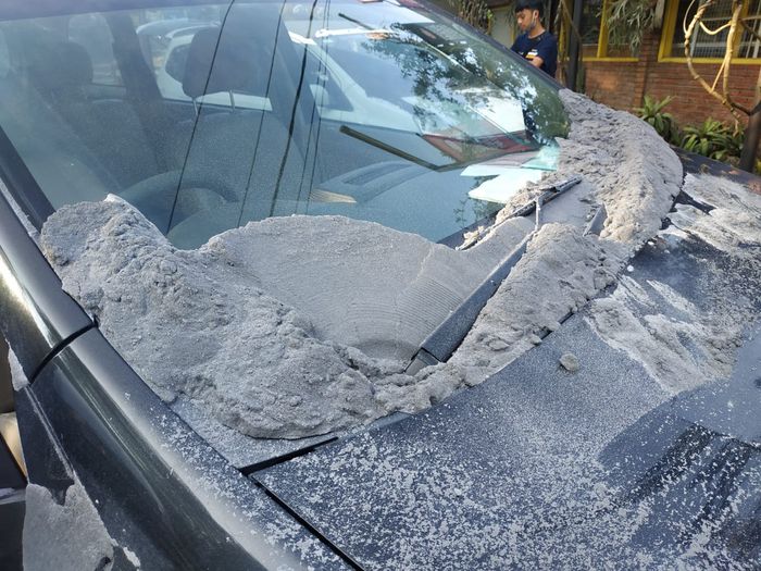 Abu Vulkanik menumpuk tebal di kaca depan Toyota Avanza