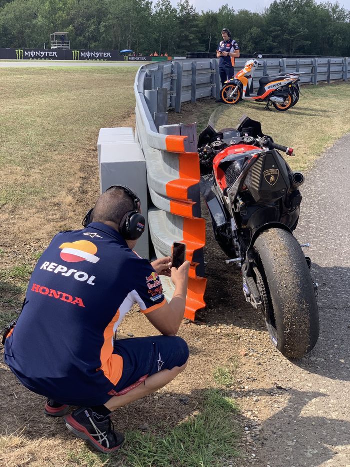 Kru Repsol Honda mengambil foto motor Ducati yang terparkir usai crash di FP1 MotoGP Ceko