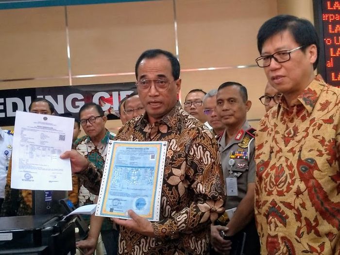 Menteri Perhubungan, Budi Karya Sumadi, menunjukkan beda e-SRUT (kiri) dan SRUT (kanan)