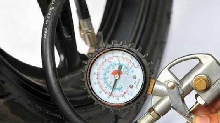 Ilustrasi mengukur tekanan ban motor.