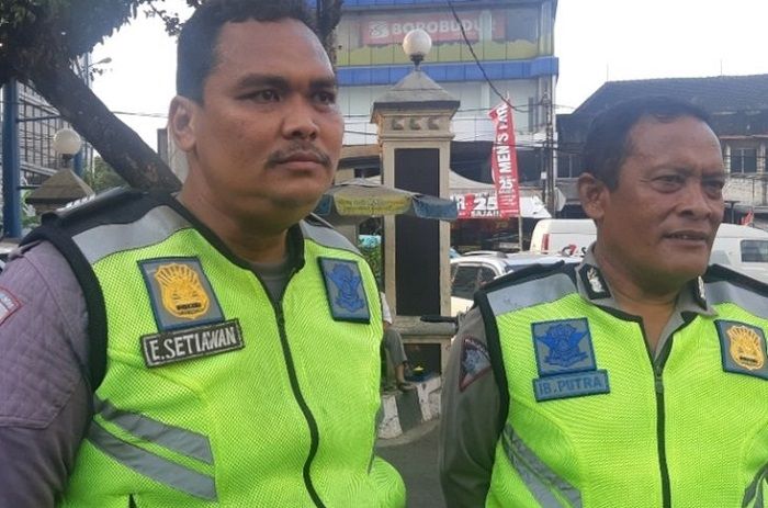 Bripka Eka Setiawan (ki), anggota Satlantas Polsek Pasar Minggu yang harus tengkurap di kap mobil untuk hentikan pelanggar lalu lintas.