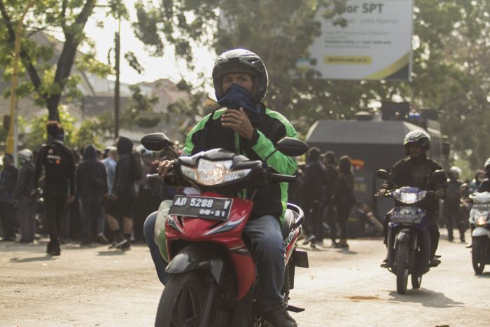 Ilustrasi pengendara ojek online menggunakan masker