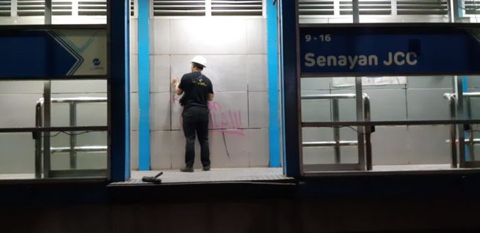 Petugas sedang membersihkan halte yang penuh coretan anarkis akibat kerusuhan di seputaran kompleks Parlemen, Senayan, Jakarta Pusat, Rabu pagi (25/9/2019). Kaca di halte itu juga ikut pecah akibat kerusuhan.