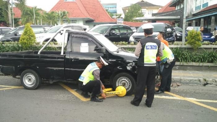 Ilustrasi penindakan pelanggar marka biku-biku dengan cara menggembok ban