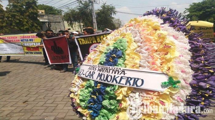 Karangan bunga yang dibuat para driver taksi online bertuliskan protes kepada GoJek