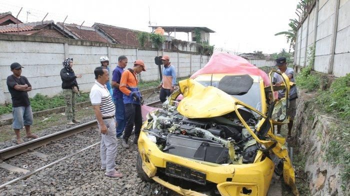 Honda Brio warna kuning ringsek setelah beradu lawan kereta api