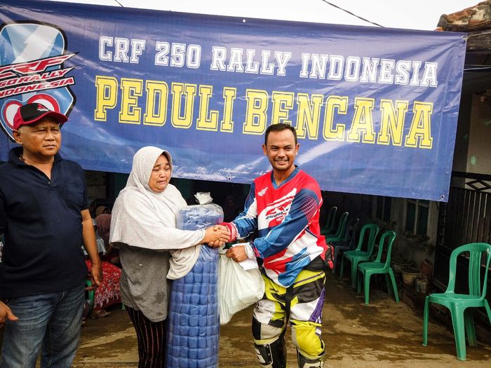 Tajul Arifin selaku President CRF 250 Rally Indonesia menyerahkan bantuan secara simbolis kepada warga ditemani bapak Rosid selaku salah satu sesepuh warga Cipanas, Lebak (4/1)