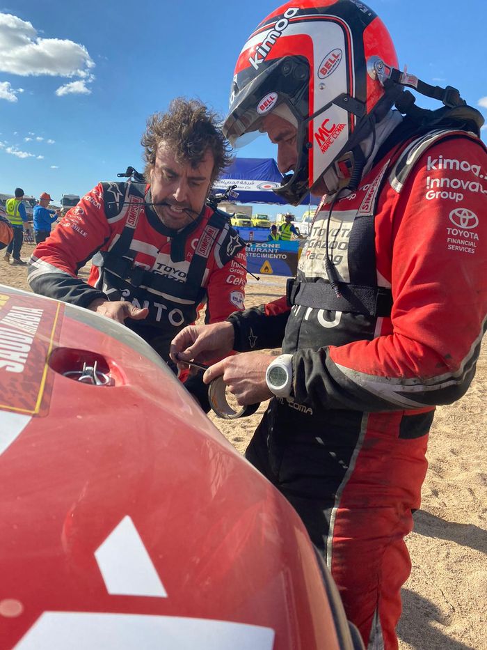 Fernando Alonso mengigit cable tie saat memperbaiki bodi mobilnya di Reli Dakar 2020, dibantu co-driver Marc Coma