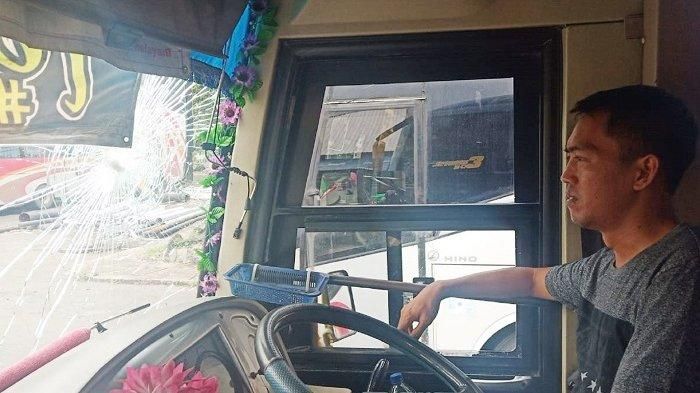 Sopir bus Sugeng Rahayu menunjukkan bagian yang rusak karena lemparan batu di Solo, Jumat (10/1/2020).  