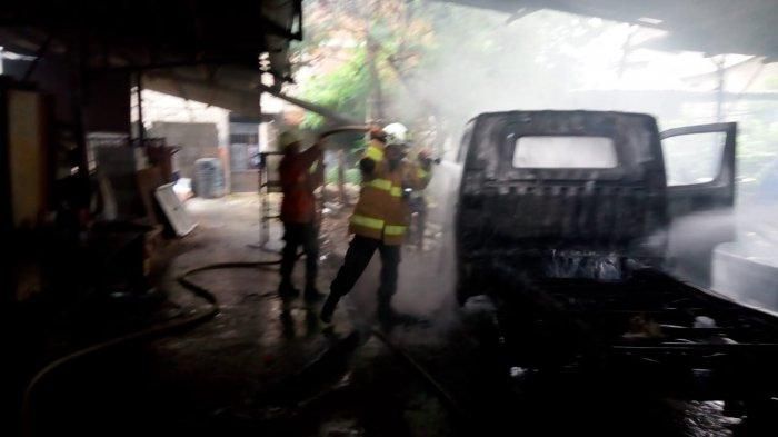 Proses pemadaman api di Daihatsu Gran Max yang terbakar saat proses pengelasan di bengkel mobil kawasan Ciracas, Jaktim