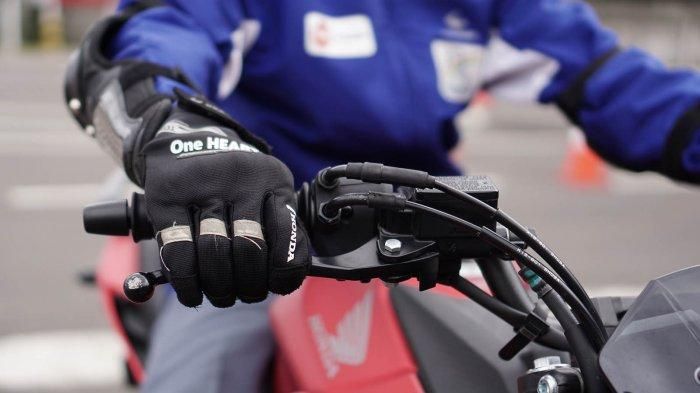 Ilustrasi mengerem motor saat melaju di kecepatan rendah