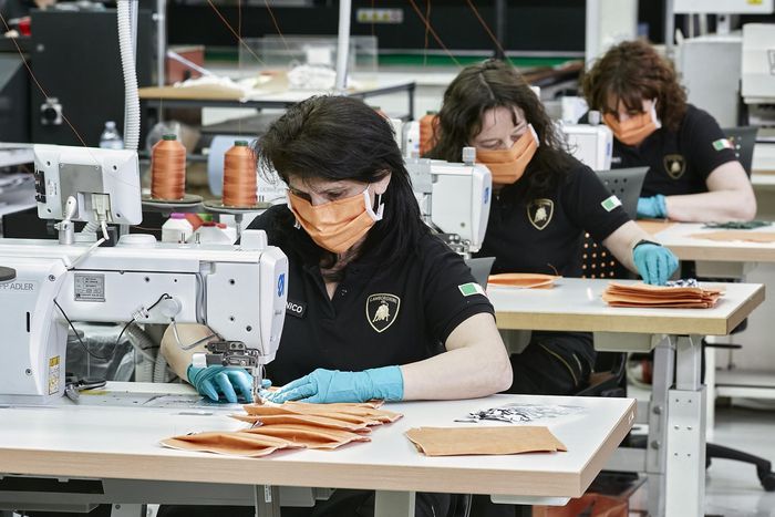 Terlihat karyawan sedang menjahit masker di pabrik Lamborghini Italia
