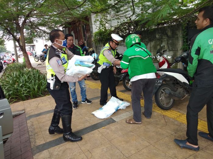 Pembagian bantuan beras kemasan 5 kilogram di halaman Polsek Palmerah, Jakarta Barat.
