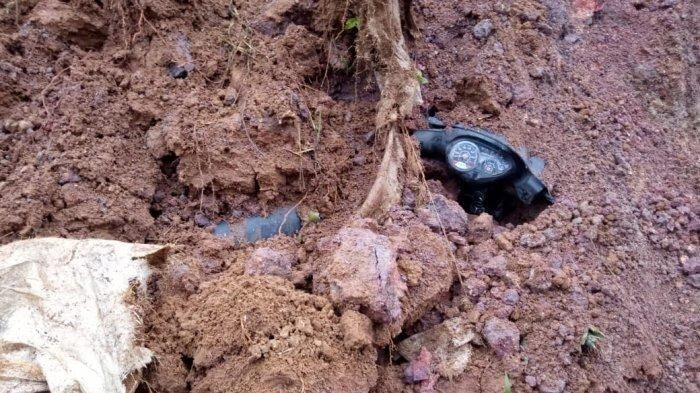 Sebuah sepeda motor tertimbun tanah longsor menyisakan setang dan batoknya saja, pengendara motor pun hampir meregang nyawa.