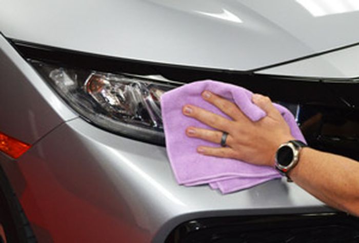 Ilustrasi mengaplikasikan coating pada headlight mobil