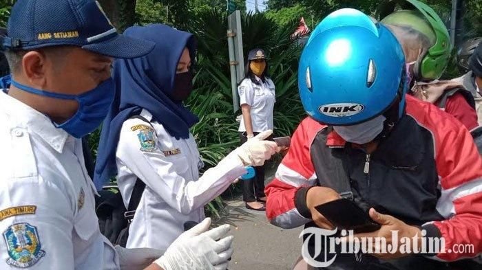 Petugas saat melakukan screening kendaraan masuk ke Surabaya di hari keempat PSBB 