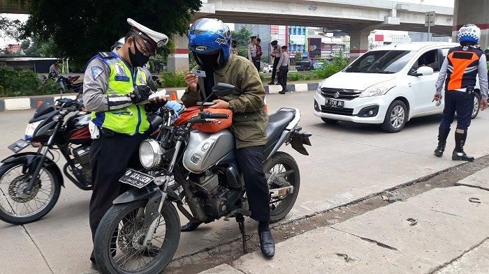 IUSTRASI - Anggota Polantas mendata pengendara yang tidak menggunakan sepeda motor di hari pertama penerapan PSBB Kota Bekasi, Rabu (15/4/2020) di Check Point Jl Lampiri, Kalimalang 