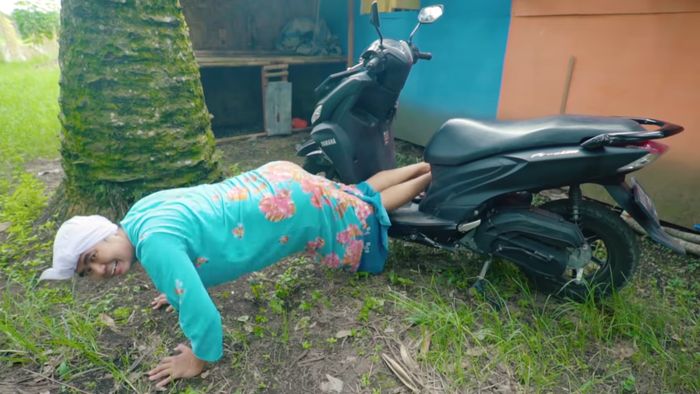 Mak Beti melakukan push up sambil bertumpu pada Yamaha FreeGo