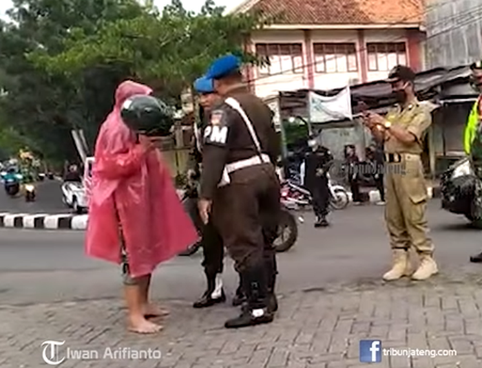 Petugas TNI berjas hujan merah muda diberhentikan oetugas Polisi Militer