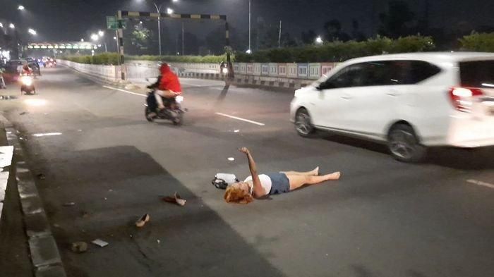 Seorang wanita muda tergeletak sembari meronta-ronta dan meracau sendirian seperti orang kesurupan di Jalan Pasar Minggu Raya, Jakarta Selatan, Kamis (14/5/2020). (Warta Kota/Vini Rizki Amelia)