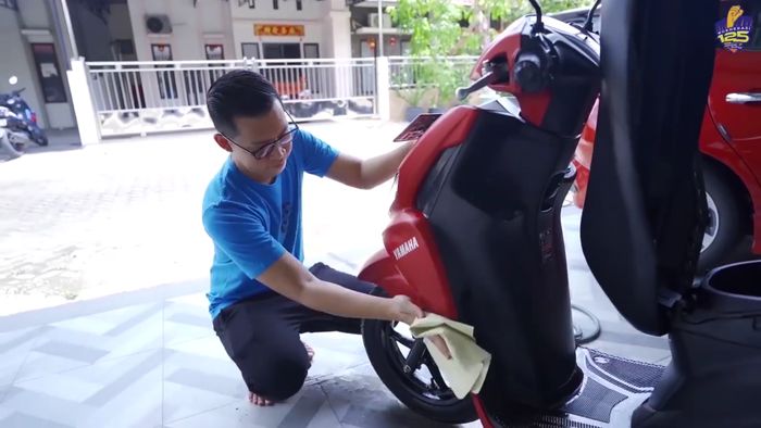 Bang Evan sedang mencuci Yamaha FreeGo S 125 kesayangannya