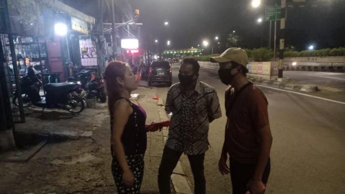 Petugas saat berbincang dengan wanita yang sempat tergeletak di Jalan Raya Pasar Minggu, Jakarta Selatan, Jumat (15/5/2020). 
