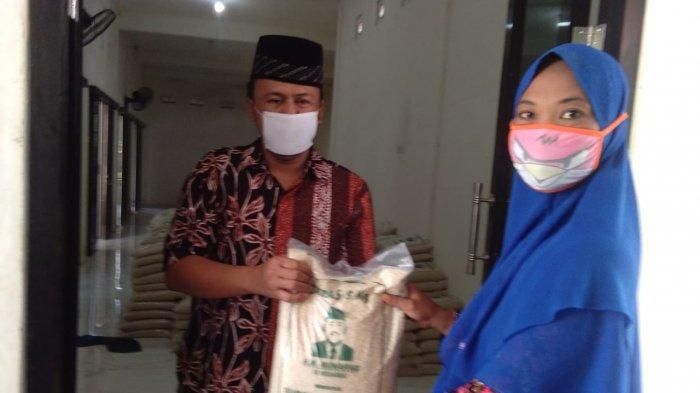 Kepala Desa Melirang, Muhammad Muaffaq membagikan beras hasil menjual mobil kesayangannya kepada warga, Jumat (22/5/2020).     