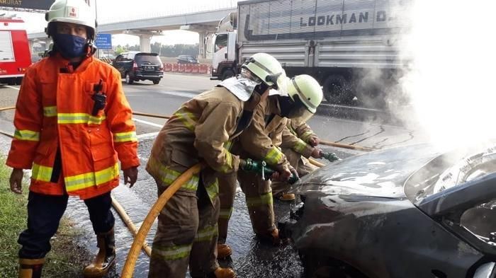 Proses pemadaman Suzuki SX4 yang terbakar di tol Jakarta-Cikampek
