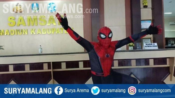 Pria berkostum Spider-Man sedang mengurus pajak kendaraan di Samsat Madiun. 