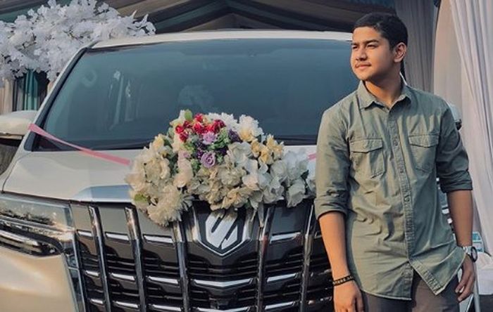 Syakir Daulay berpose di depan Toyota Alphard 