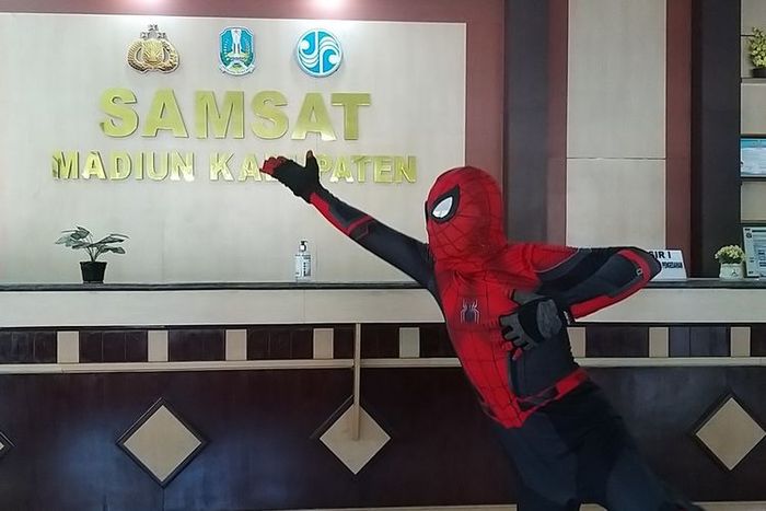 Nyono, pria berkostum Spiderman memperagakan aksi bak superhero di Samsat Madiun.