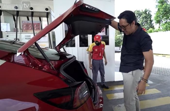 Andre Taulany membuka bagasi mobil saat mencari letak tangki BBM