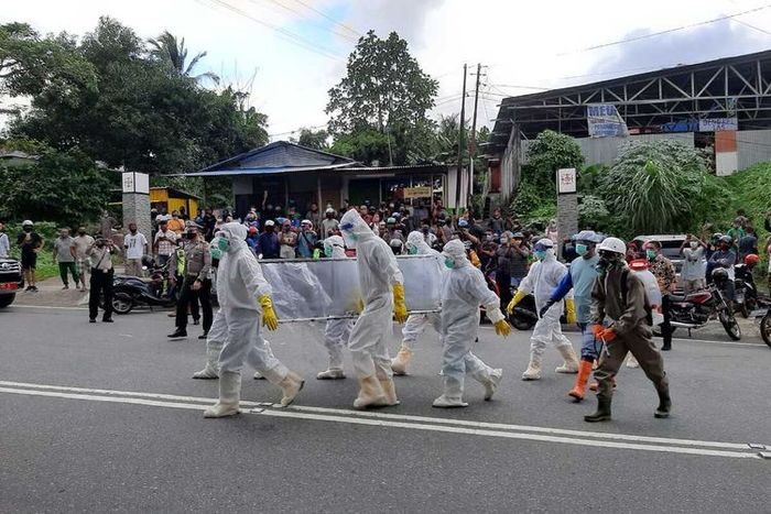 Tim gugus Tugas Covid-19 menyiagakan sebuah mobil ambulans untuk membawa kembali jasad pasien Covid-19 yang sebelumnya diambil paksa pihak keluarga, Jumat (26/6/2020). Upaya membawa kembali jenazah Covid-19 itu ikut dikawal ratusan anggota polisi di kawasan tersebut.