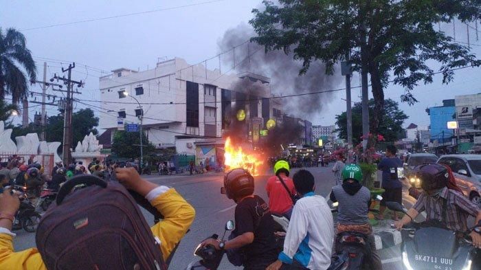 Petugas pemadam kebakaran menyemprotkan air ke angkutan umum, Jumat (3/7/2020). (TRIBUN MEDAN / ist)