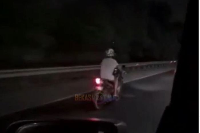 Seorang pengendara sepeda motor yang menurut keterangan polisi dalam kondisi mabuk melintas di Jalan Tol JORR Bekasi, Jawa Barat, Rabu (5/8/2020). Orang itu kemudian dihentikan polisi.