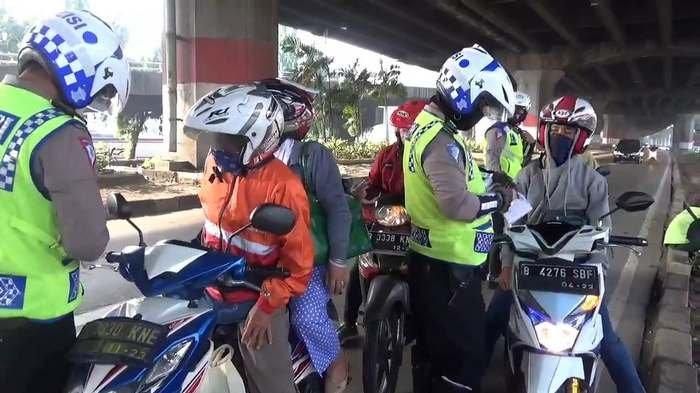 Petugas melakukan penilangan terhadap motor yang masuk jalur cepat Jalan DI Panjaitan, Jakarta Timur, Kamis (6/8/2020)