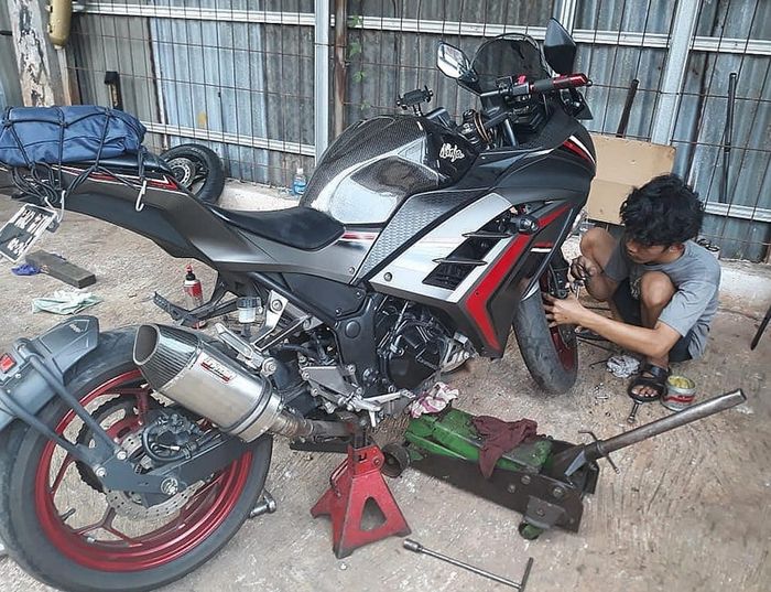 Proses pembongkaran sokbreker motor, pakai bantuan dongkrak