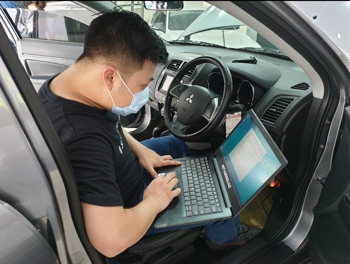 Seorang teknisi sedang melakukan remap ECU mobil customer