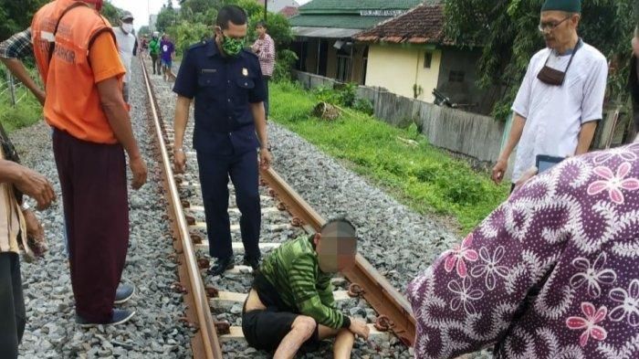 Warga berdatangan sesaat setelah lokomotif lewat dan Juju (52) ternyata masih hidup dan bahkan bangkit untuk duduk.  