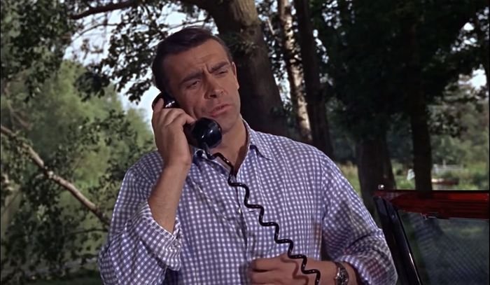 James Bond yang diperankan Sean Connery sedang menerima panggilan dari Miss Moneypenny melalui telpon di Bentley Mark IV Drophead.