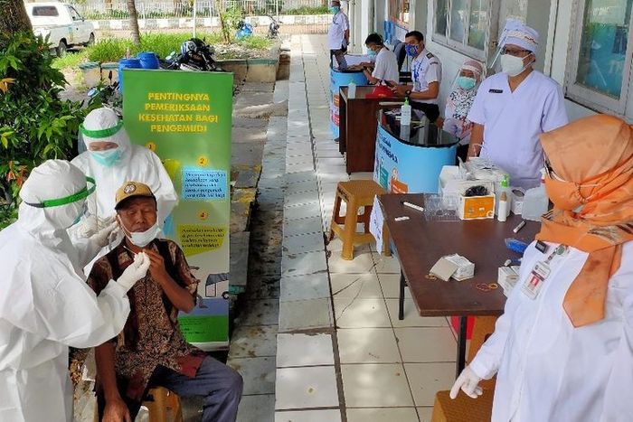 Petugas kesehatan dari Puskesmas Margadana Dinas Kesehatan Kota Tegal melakukan pemeriksaan swab antigen virus Covid-19 kepada sopir bus di Terminal Bus Kota Tegal, Rabu (16/12/2020)(KOMPAS.com/Tresno Setiadi)