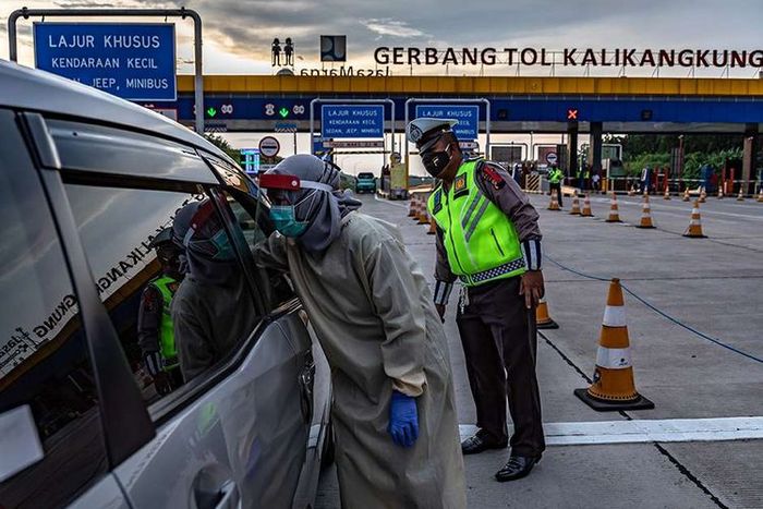 Petugas kesehatan memeriksa suhu pengendara roda empat saat penyekatan pemudik di Gerbang Tol Kalikangkung, Semarang, Jawa Tengah, Selasa (26/5/2020). 
