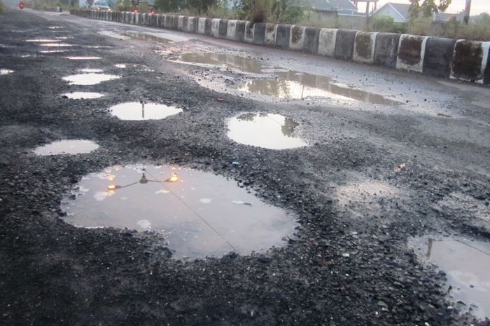 ruas jalan yang berlubang setelah diguyur hujan.