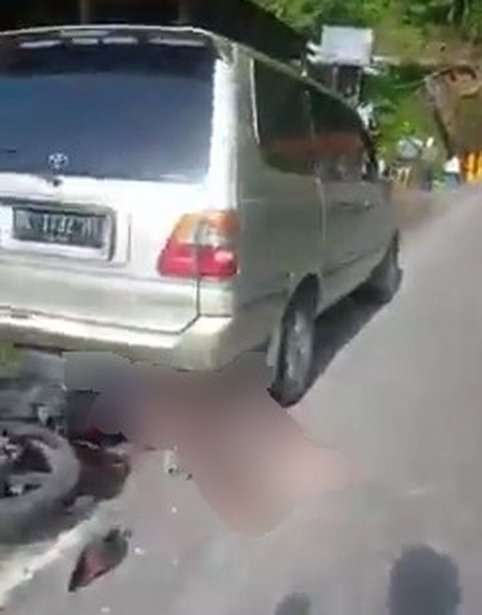 Salah seorang korban yang tergeletak di belakang Toyota Kijang dan terhimpit motornya